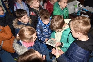 Dzieci oglądają odznaczony na papierze ślad linii papilarnych.