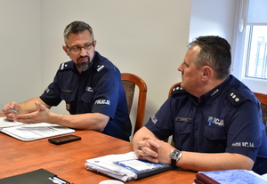 Umundurowani policjanci siedzą przy stole.