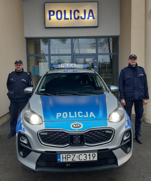 Umundurowani policjanci z Komisariatu Policji w Jadowie stoją przy radiowozie.