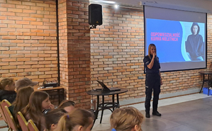 Policjantka w mundurze służbowym mówi do uczestników spotkania